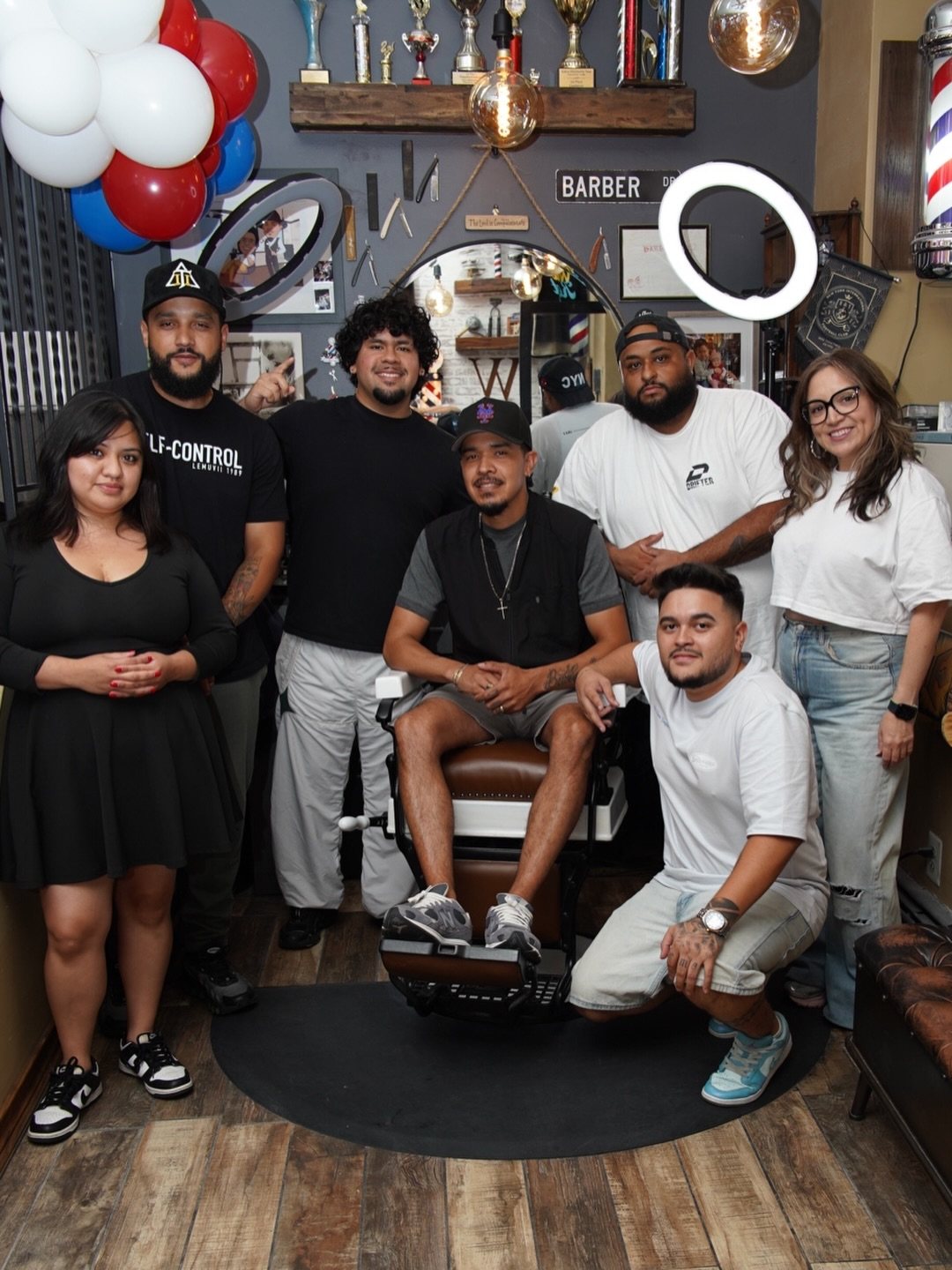 The Well Kept team in the shop, Ruben seated in the barber chair